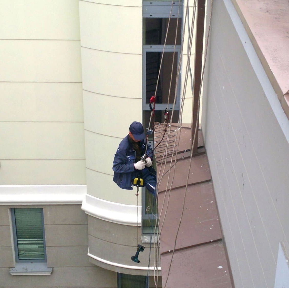 Сотрудник "Мособогрев" рискует, исполняя монтаж системы обогрева кровли