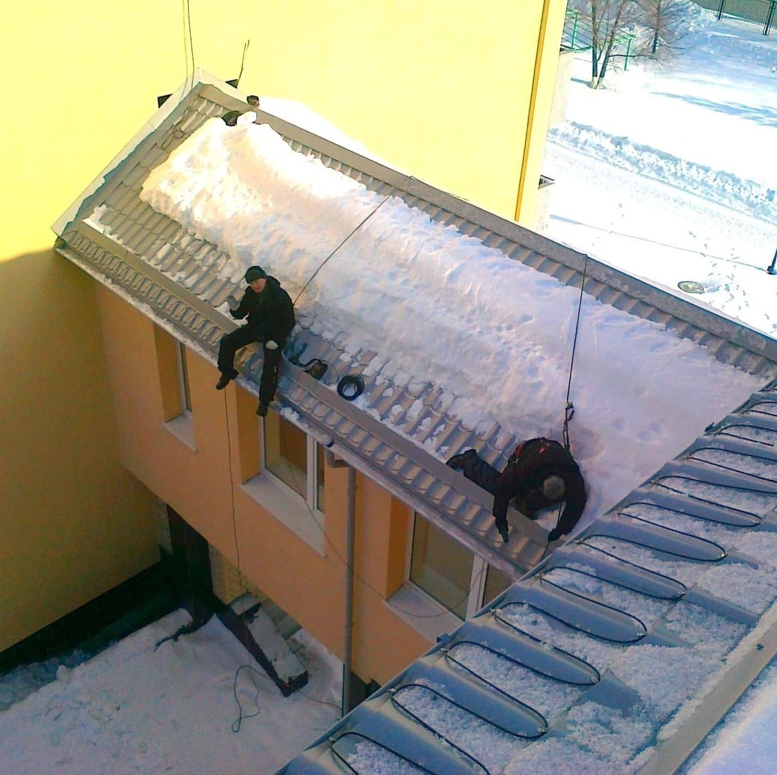 Сотрудники "Мособогрев" веселятся при монтаже обогрева водостоков